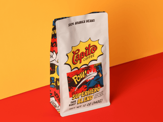 A case of Capito Coffee Superhero Blend, featuring comic book art with "POW!" and a superhero on a red-orange background. Crafted from 100% Arabica beans, this dark roast is perfect for bold coffee fans. Net Wt. 12 oz (340g) per bag.