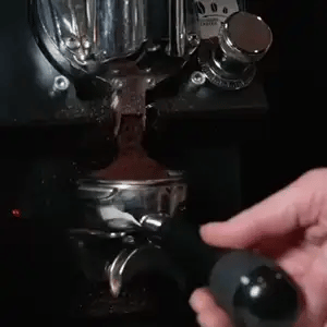 Fresh coffee being ground, tamped, pulled and poured